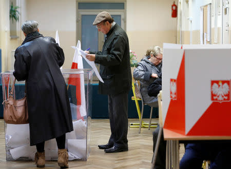 People attend the Polish regional elections, at a polling station in Warsaw, Poland, October 21, 2018. REUTERS/Kacper Pempel