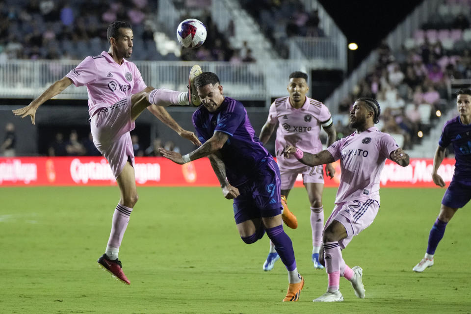 Inter Miami midfielder Sergio Busquets (5) connects with the head of Charlotte FC forward Enzo Copetti (9) during the first half of an MLS soccer match, Wednesday, Oct. 18, 2023, in Fort Lauderdale, Fla. (AP Photo/Rebecca Blackwell)