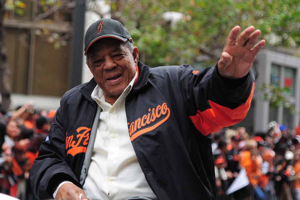 Willie Mays waves to the crowd while riding in a car during the 2012 World Series victory parade.