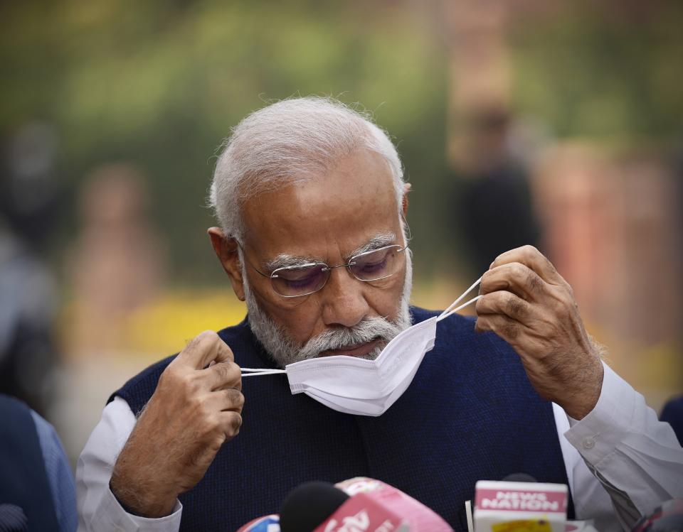 Indian Prime Minister Narendra Modi, removes his mask before addressing the media on the opening day of the winter session of Parliament in New Delhi, India, Monday, Nov.29, 2021. India’s parliament on Monday repealed a set of controversial agriculture laws that inflamed tens of thousands of farmers, whose year-long protest has posed one of the biggest challenges to Prime Minister Narendra Modi’s administration. (AP Photo/Manish Swarup)