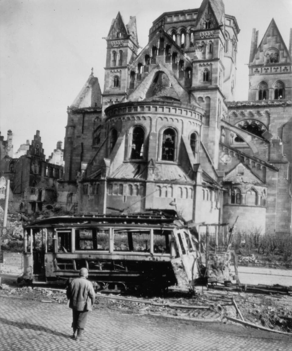 A U.S. soldier surveys the wreckage of a trolley car and a damaged cathedral after U.S. Third Army troops swept into the German city of Koblenz on the Rhine River.