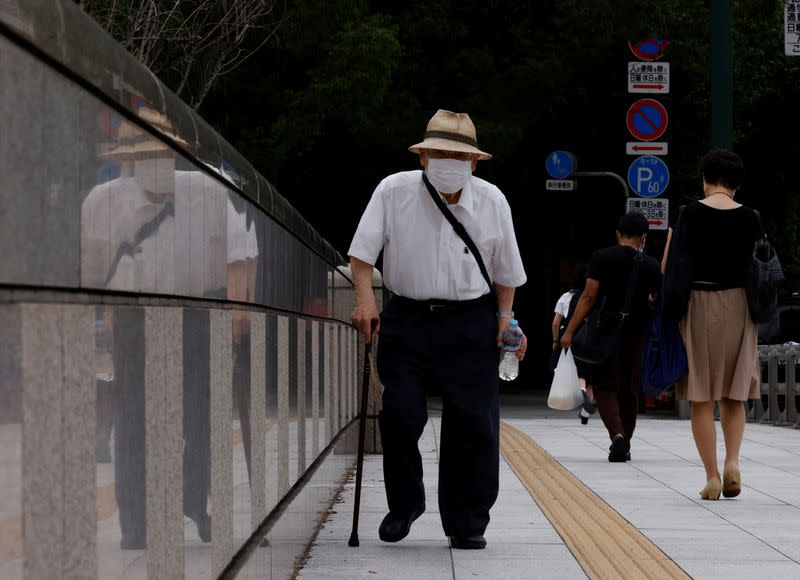 A man wearing a protective mask makes his way as the nation's capital, Tokyo, reported 31,878 cases of daily infections, surpassing the 30,000 mark for the first time amid the coronavirus disease (COVID-19) pandemic in Tokyo