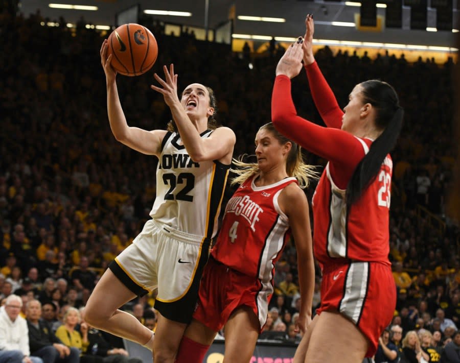 Iowa guard Caitlin Clark (22) drives to the basket under pressure from Ohio State guard Jacy Sheldon (4) and forward Rebeka Mikulasikova (23) during the second half of an NCAA college basketball game, Sunday, March 3, 2024, in Iowa City, Iowa. (AP Photo/Cliff Jette)