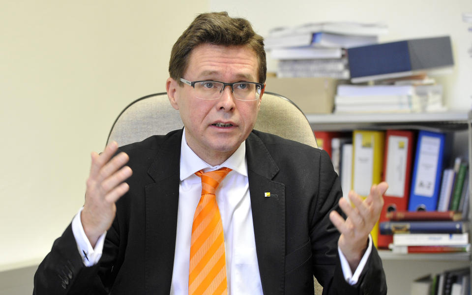 In this picture taken Tuesday, Jan. 21, 2014, law professor Martin Pollaschek speaks during an interview with The Associated Press on Nazi symbols on gravestones at a cemetary in Graz, Austria. Austrian law bans such symbols, and those displaying them face criminal charges and potential prison terms. Yet the emblems reflecting this country’s darkest chapter in history endure here, and officials here appear either unable or unwilling to do away with them. (AP Photo/Hans Punz)