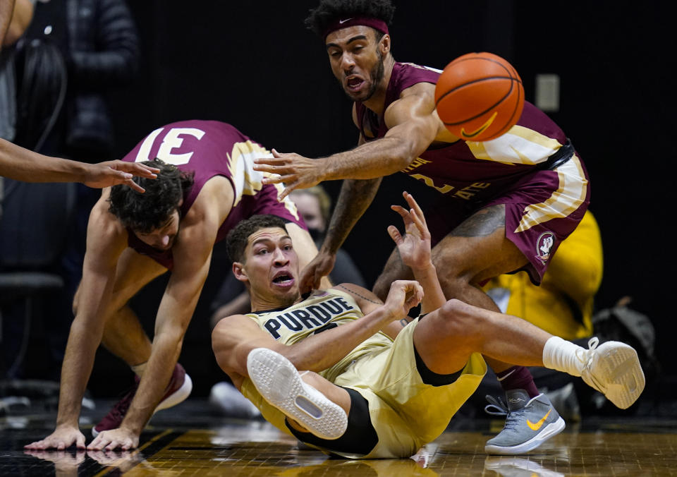 Purdue forward Mason Gillis (0) makes a pass from the floor in front of Florida State guard Anthony Polite (2) during the first half of an NCAA college basketball game in West Lafayette, Ind., Tuesday, Nov. 30, 2021. (AP Photo/Michael Conroy)