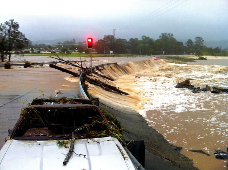 Floodwaters race across the Oxenford - Tamborine road as severe floods threaten to inundate thousands of properties in Australia's Gold Coast on January 28, 2013