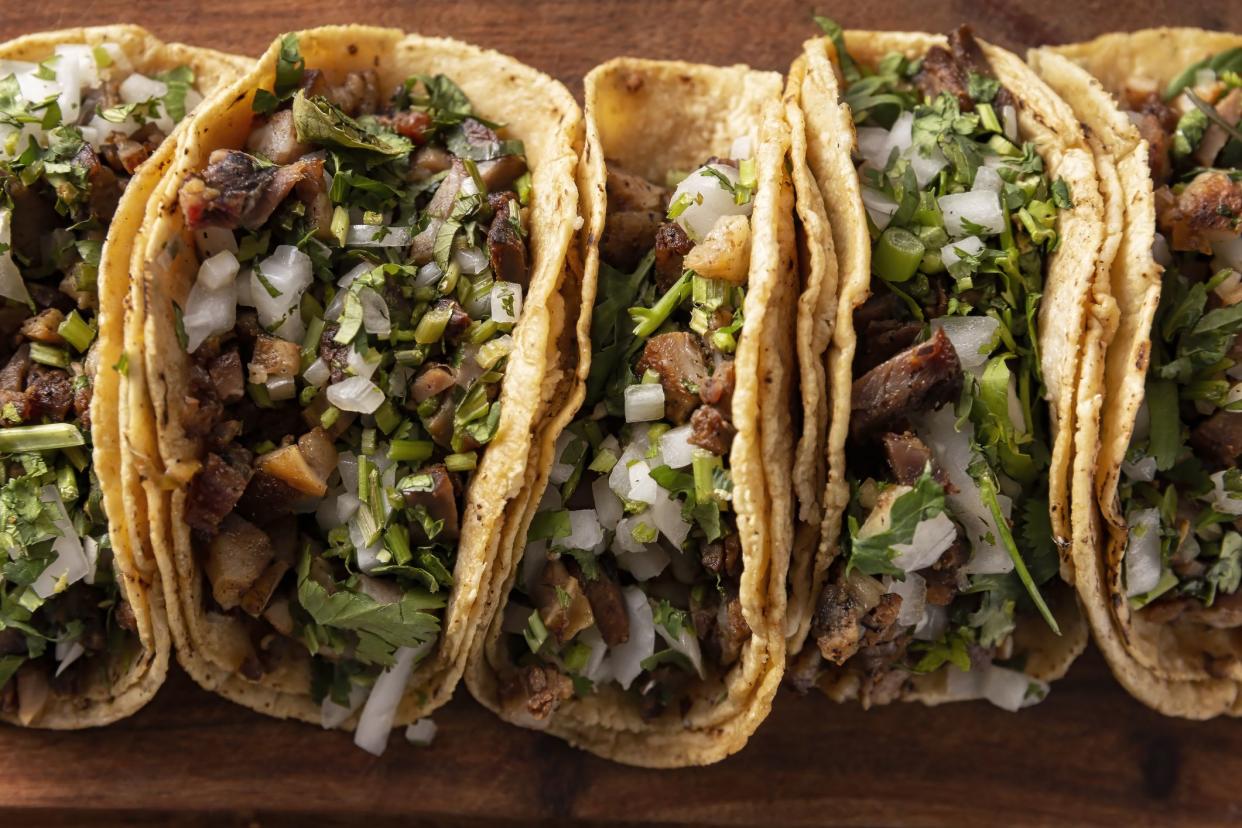 Tacos de Suadero. Fried meat in a corn tortilla. Street food from CDMX, Mexico, traditionally accompanied with cilantro, onion and spicy red sauce