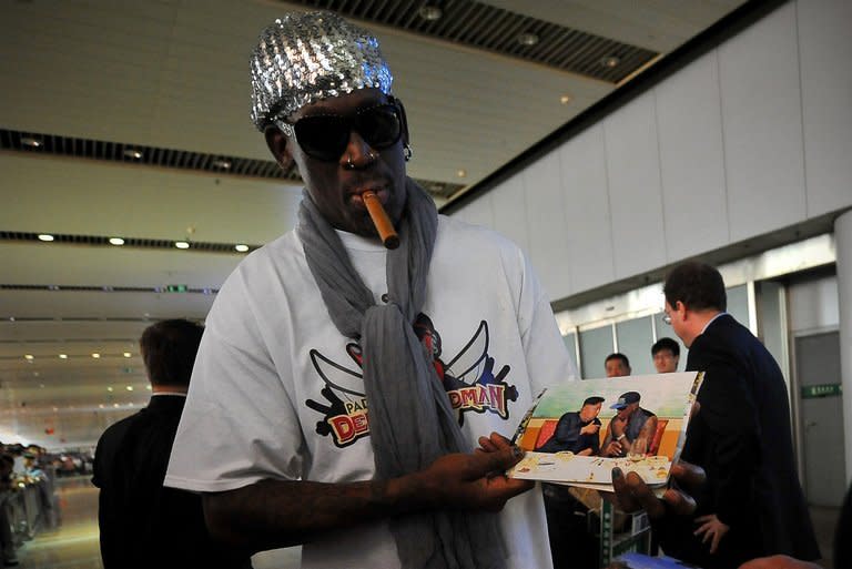 Dennis Rodman shows pictures of him reportedly with North Korea's Kim Jong-Un to the media at the Beijing airport on September 7, 2013. Rodman returned to China from Pyongyang Saturday after a five-day trip when he met the North Korean leader, but without jailed American Kenneth Bae