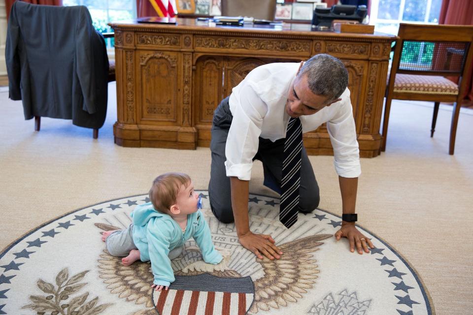 Obama crawls on the ground with Communications Director Jen Psaki's daughter Vivi on April 14.
