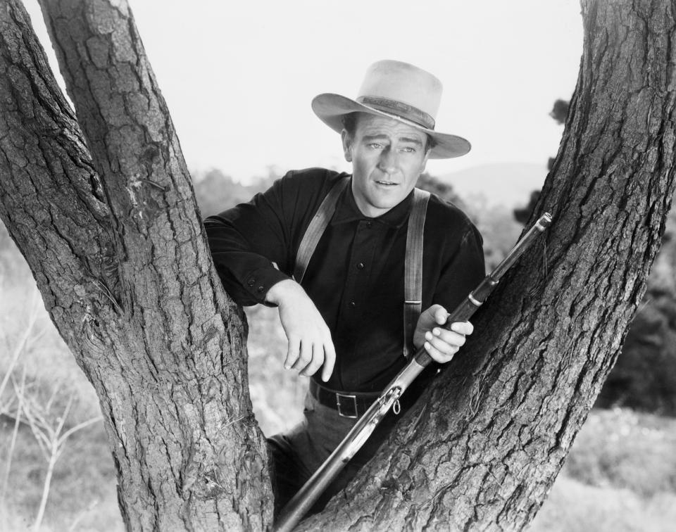 (Original Caption) 1940-John Wayne as he appeared in the film "Shepherd of the Hills: resting his rifle in the fork of a tree. Photograph, 1940. Movie Still. Movie released in 1941. (Photo by AS400 DB/Bettmann Archive)