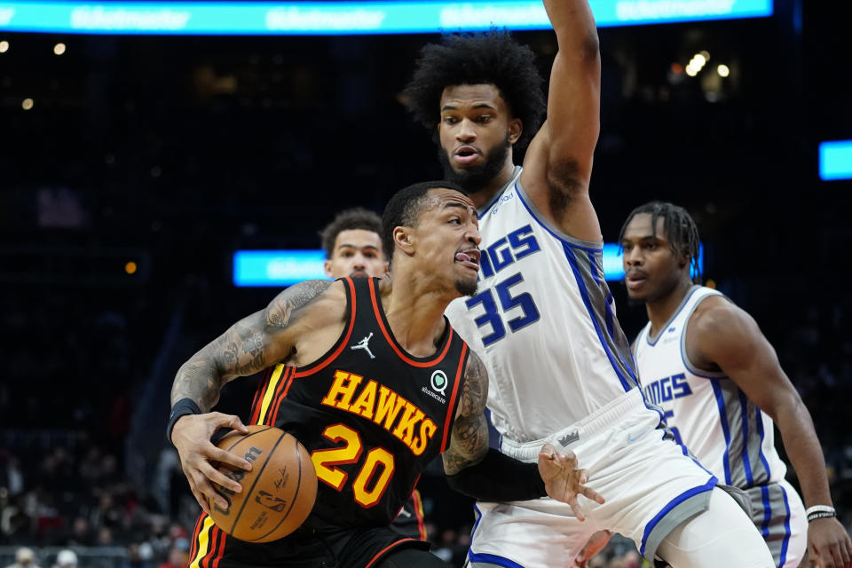 Atlanta Hawks' John Collins (20) drives against Sacramento Kings forward Marvin Bagley III (35) in the first half of an NBA basketball game Wednesday, Jan. 26, 2022, in Atlanta. (AP Photo/John Bazemore)