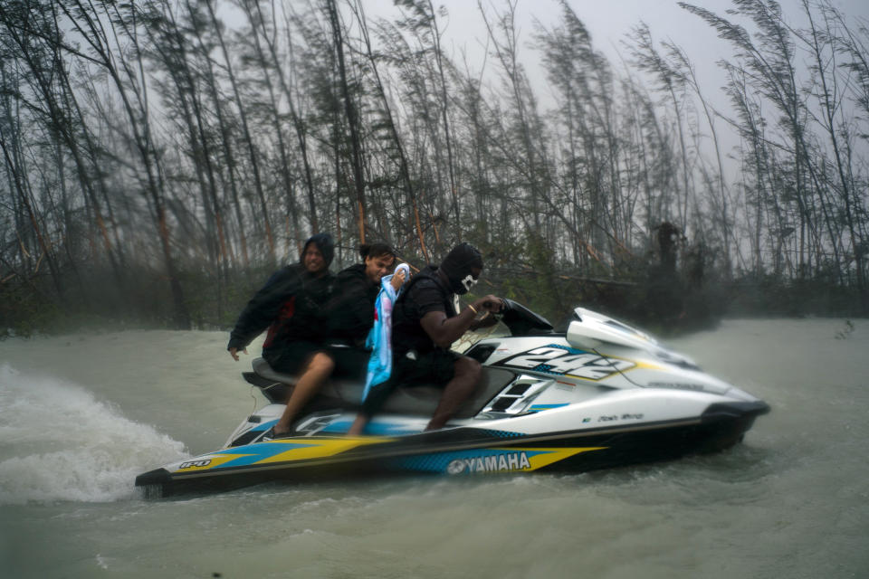 A woman who was trapped by flood waters during Hurricane Dorian is transported out of the area by volunteers on a jet ski near the Causarina bridge in Freeport, Grand Bahama, Bahamas, Tuesday, Sept. 3, 2019. The storm’s punishing winds and muddy brown floodwaters devastated thousands of homes, crippled hospitals and trapped people in attics. (AP Photo/Ramon Espinosa)