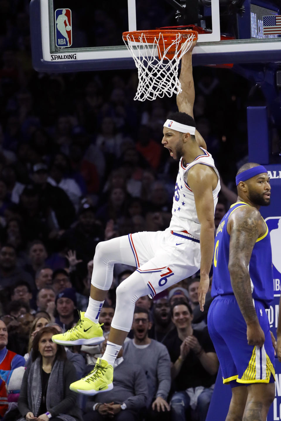 Philadelphia 76ers' Ben Simmons, left, reacts after dunking past Golden State Warriors' DeMarcus Cousins during the first half of an NBA basketball game, Saturday, March 2, 2019, in Philadelphia. (AP Photo/Matt Slocum)