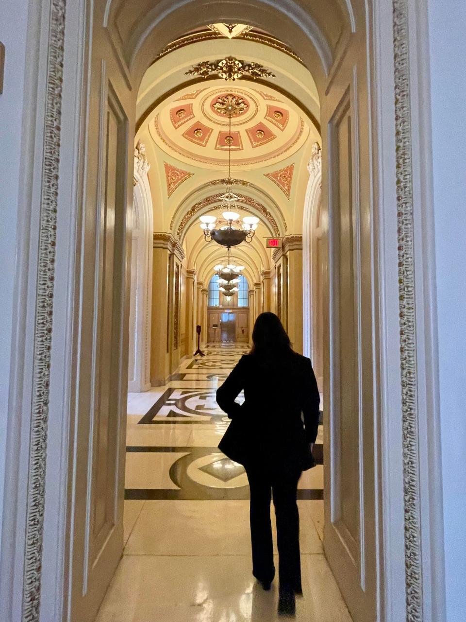 Athina Lawson walking down a hallway in the U.S. capitol building.