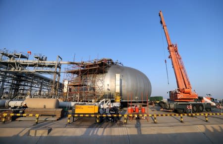 Workers are seen at the damaged site of Saudi Aramco oil facility in Abqaiq