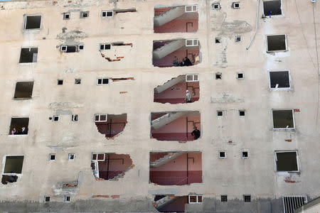 Residents stand inside a building, which was damaged during Friday's car bomb attack, in the Kurdish-dominated southeastern city of Diyarbakir, Turkey, November 5, 2016. REUTERS/Sertac Kayar