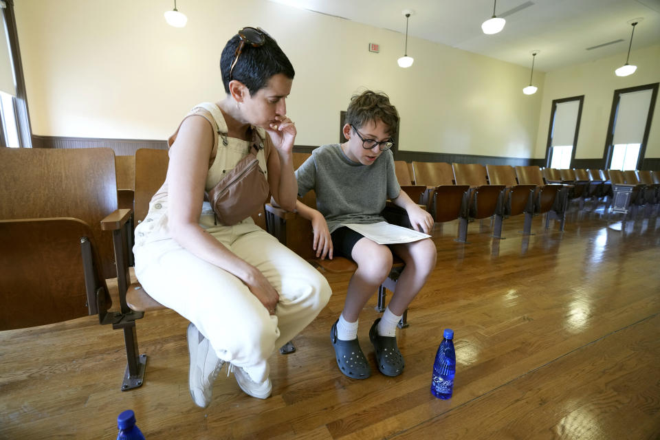 Zev Berry, 13, right, reads to his mother Ilana Berry, left, a copy of a community apology issued several years ago by a group of Tallahatchie County residents to the family of Emmett Till, over what they believed was a miscarriage of justice during his murder trial in the Tallahatchie County Second District Courthouse, Monday, July 24, 2023, in Sumner, Miss. President Joe Biden is expected to create a national monument honoring Emmett Till, the Black teenager from Chicago whose abduction, torture and killing in Mississippi in 1955 helped propel the civil rights movement. (AP Photo/Rogelio V. Solis)