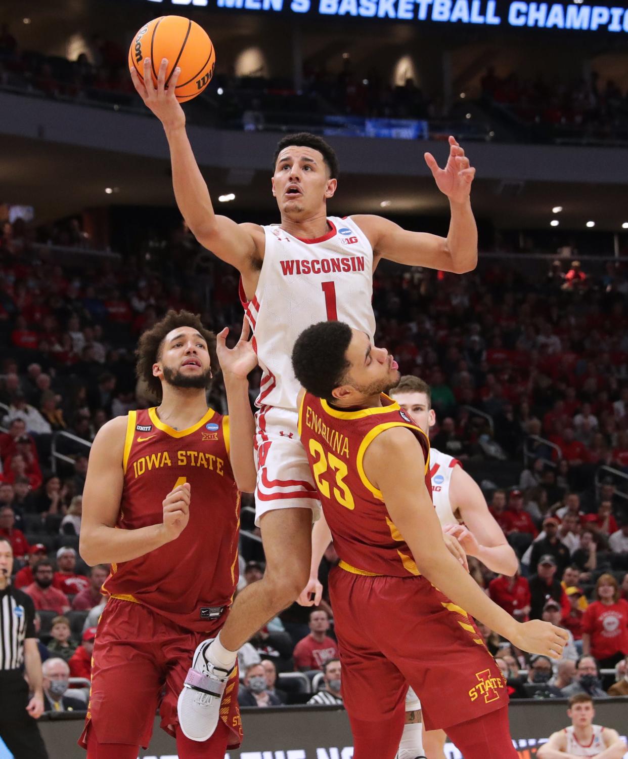 Wisconsin guard Johnny Davis fouls Iowa State guard Tristan Enaruna.