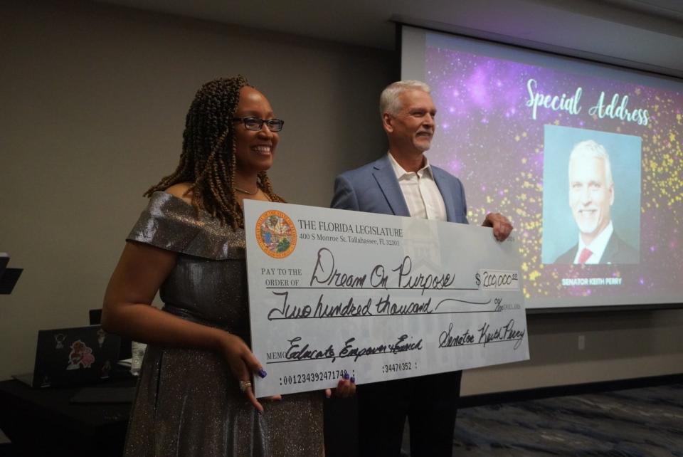 Dream on Purpose President and Co-Founder Shareen Baptiste, left, holds a $200,000 state-grant check with State Sen. Keith Perry, R-Gainesville, right, during the 8th annual Dream on Purpose Dinner. Perry helped secure the funds for the nonprofit that was officially incorporated in 2015 to impact the lives of youth through education and life skills.
(Credit: Photo by Voleer Thomas, Correspondent)