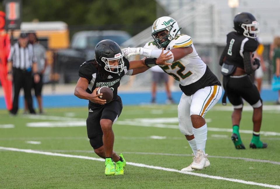 Windsor Forest quarterback Anthony Williams attempts to scramble away from Savannah Country Day's Rooster Bing during their season opener at Savannah High on Thursday, August 17, 2023.