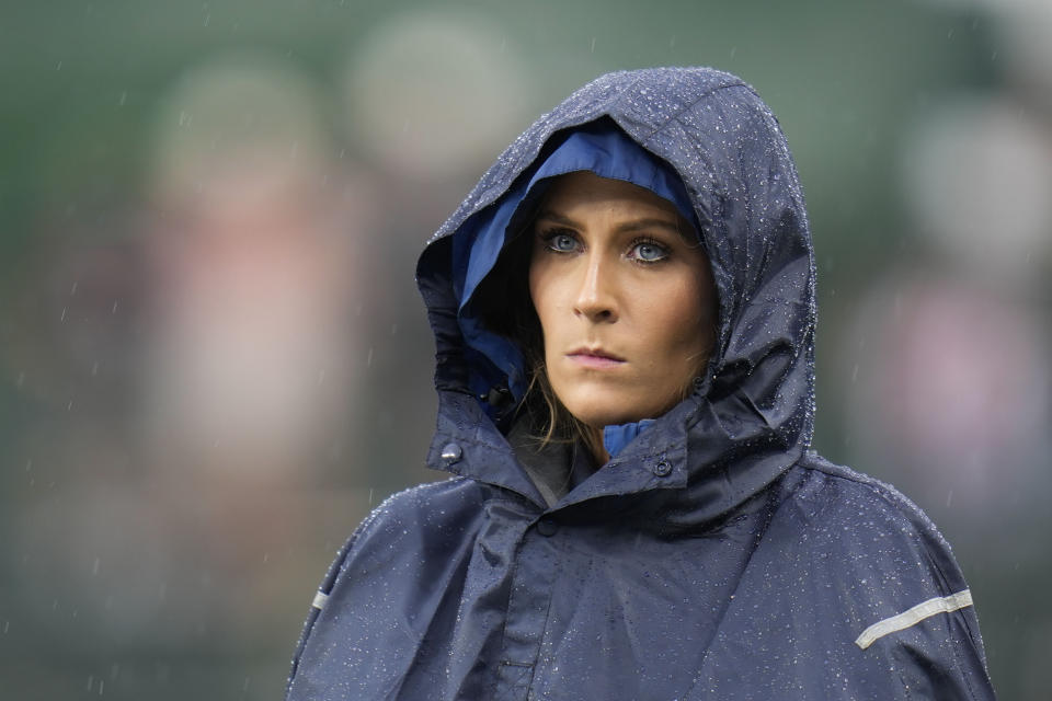 Wrigley Field worker Amy Laske stands on the field during a second rain delay during the seventh inning of a baseball game between the St. Louis Cardinals and Chicago Cubs, Saturday, July 22, 2023, in Chicago. (AP Photo/Erin Hooley)