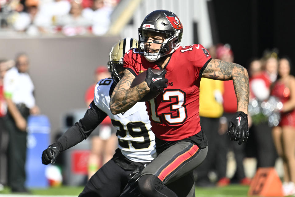 Tampa Bay Buccaneers wide receiver Mike Evans (13) carries against New Orleans Saints cornerback Paulson Adebo (29) in the first half of an NFL football game in Tampa, Fla., Sunday, Dec. 31, 2023. (AP Photo/Jason Behnken)