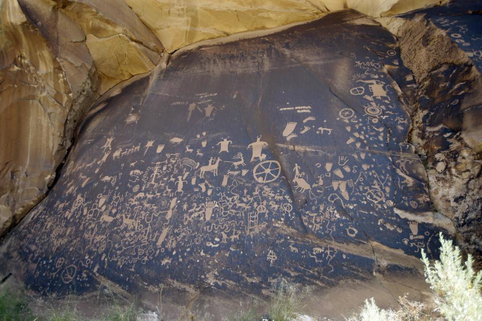 FILE - In this July 14, 2016, file photo, the Newspaper Rock featuring a rock panel of petroglyphs in the Indian Creek Area is shown to U.S. Interior Secretary Sally Jewell near Monticello, Utah, during a tour to meet with proponents and opponents to the "Bears Ears" monument proposal. President Barack Obama on Wednesday, Dec. 28, designated two new national monuments in Utah and Nevada. The Bears Ears National Monument in Utah will cover 1.35 million acres of tribal land in the Four Corners region. (AP Photo/Rick Bowmer, File)