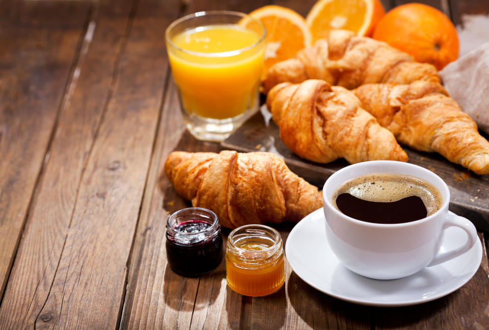 Ein Frühstückstisch gefüllt mit Croissants, Kaffee und Orangensaft (Symbolbild: Getty Images)