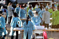 FILE - In this June 27, 2020, file photo, medical personnel prepare to test hundreds of people lined up in vehicles in Phoenix's western neighborhood of Maryvalefor free COVID-19 tests organized by Equality Health Foundation, which focuses on care in underserved communities. The personal protective gear that was in dangerously short supply during the initial weeks of the coronavirus crisis in the U.S. is running out again as the virus resumes its rapid spread and the number of hospitalized patients climbs. (AP Photo/Matt York, File)