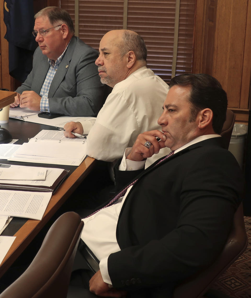 Kansas legislative leaders follow a presentation from Kansas Department of Corrections officials seeking permission to spend extra dollars in the budget at state prisons, Wednesday, June 5, 2019, at the Statehouse in Topeka, Kansas. They are, bottom right to upper left, House Appropriations Committee Chairman Troy Waymaster, R-Bunker Hill; House Minority Leader Tom Sawyer, D-Wichita, and House Majority Leader Dan Hawkins, R-Wichita. (AP Photo/John Hanna)