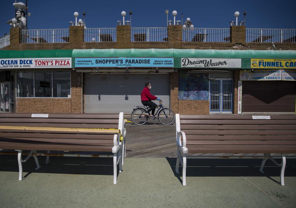 A man rides a bike on the boardwalk in Ocean City, Md., on May 10 as the area reopens after being closed for the coronavirus pandemic.