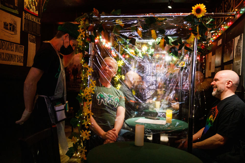 Daniel Onzo, left, chats with Brendan Byrnes, center, and his husband Stephen Cabral at the Julius' bar. (Julius Constantine Motal / NBC News)