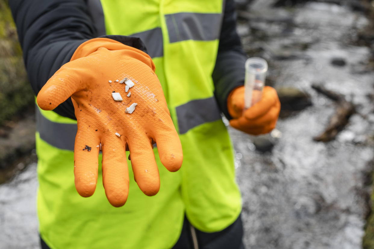 A close-up of a female scientist holding up a collection of small plastics she has found whilst collecting samples of water in Hexham in the North East of England.