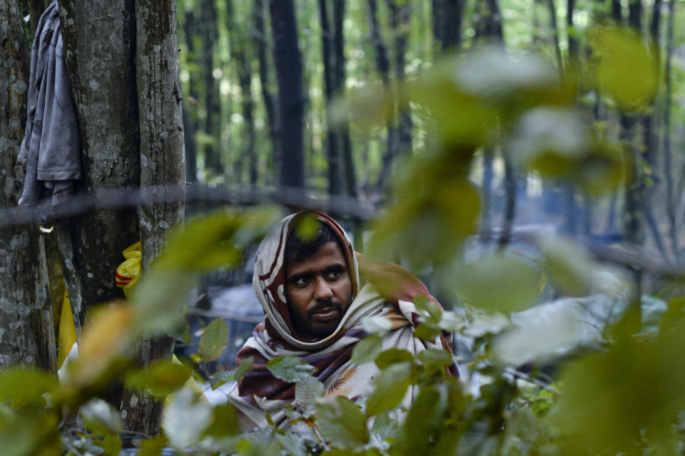 A migrant man wrapped in a blanket sits at a makeshift camp outside Velika Kladusa, Bosnia, Saturday, Sept. 26, 2020.(AP Photo/Kemal Softic)