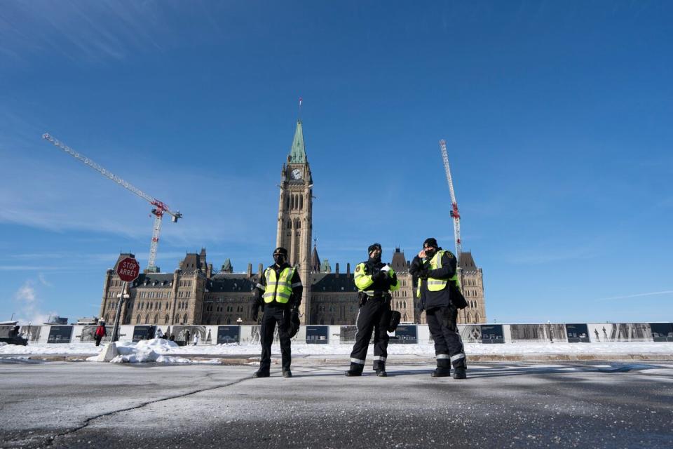 A few Parliamentary Protective Service officers stand on Parliament Hill as the number of protesters began to swell on Jan. 28, 2022.