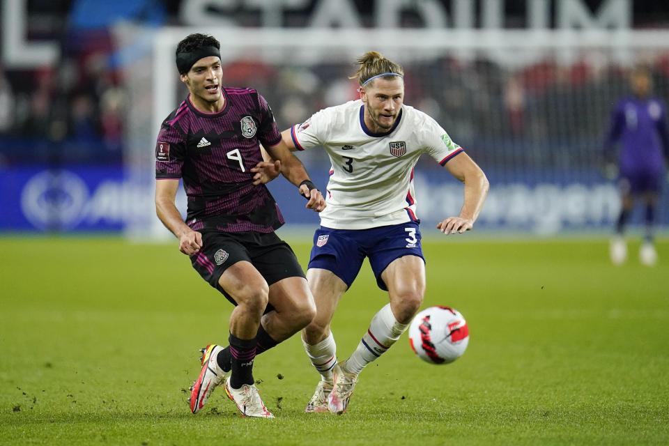 Mexico's Raul Jimenez, left, and United States' Walker Zimmerman compete for the ball during the first half of a FIFA World Cup qualifying soccer match, Friday, Nov. 12, 2021, in Cincinnati. (AP Photo/Julio Cortez)