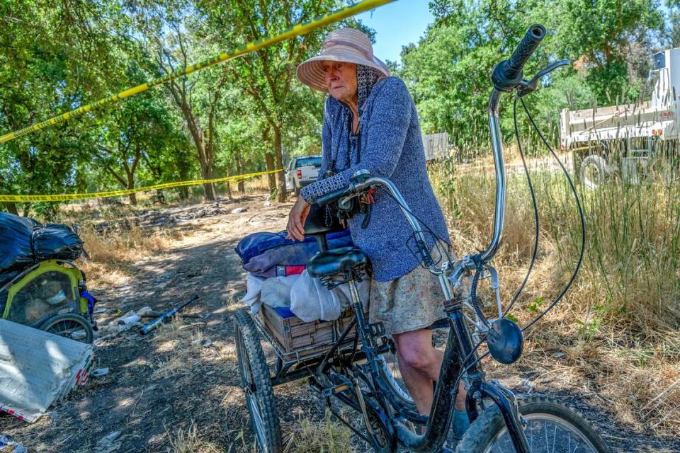 Carol Dutcher, 60, rests between police tape after moving some of her belongings during a sweep at a homeless encampment where she had lived for the past four years in Rio Linda on Monday.. “They don’t care that they destroyed my home and I have no where to go or place to sleep tonight,” she said in tears.