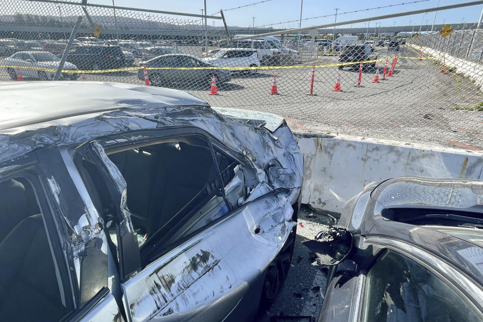 Damaged cars are seen in an on-airport employee parking lot after tire debris from a Boeing 777 landed on them at San Francisco International Airport, Thursday, March 7, 2024. A United Airlines jetliner bound for Japan made a safe landing in Los Angeles on Thursday after losing a tire while taking off from San Francisco. (AP Photo/Haven Daley)