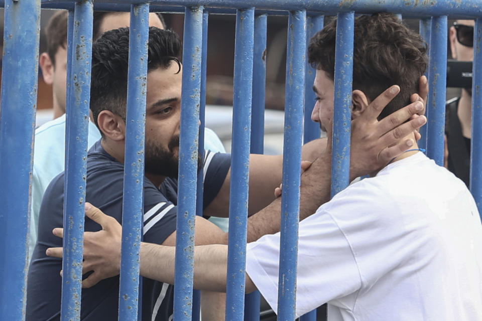 Syrian survivor Fedi, 18, right, one of 104 people who were rescued from the Aegean Sea after their fishing boat crammed with migrants sank, reacts as he reunites with his brother Mohammad, who came from Italy to meet him, at the port of Kalamata, Greece, Friday, June 16, 2023. The round-the-clock effort continued off the coast of southern Greece despite little hope of finding survivors or bodies after none have been found since Wednesday, when 78 bodies were recovered and 104 people were rescued. (John Liakos/InTime News via AP)