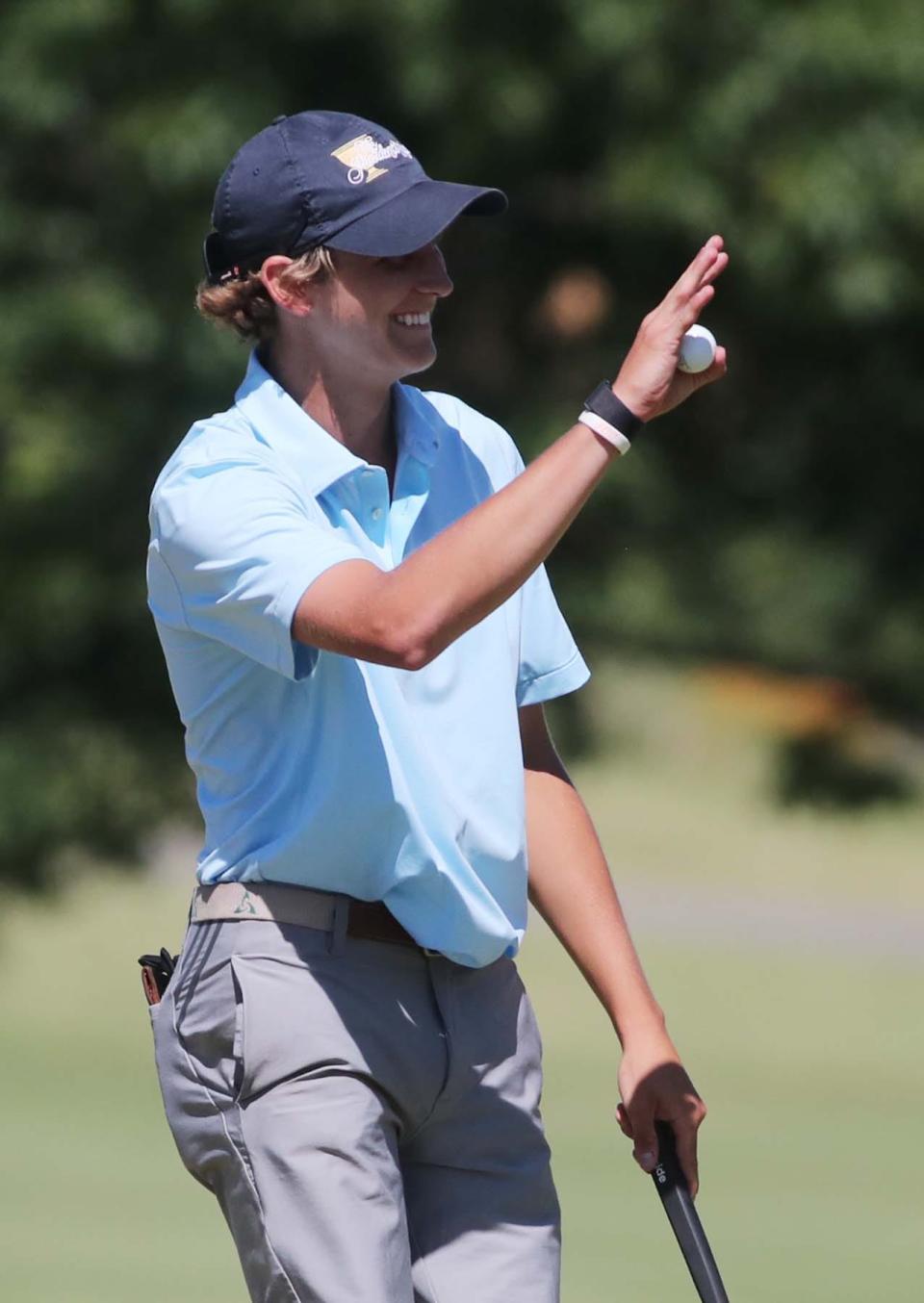 Brett Podobinski of Dublin waves to fans after sinking a putt on the 18th hole during the Hudson Junior Golf Tournament at the Country Club of Hudson Thursday. He finished the tournament tied for second place.