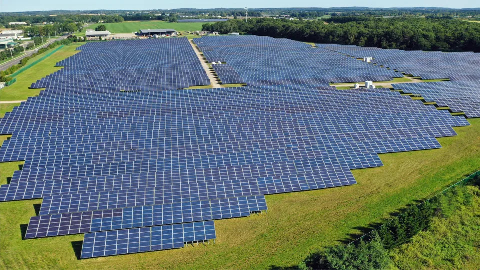 An aerial view of a large array of solar panels in a field.