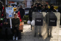 A young girl holds a placard next to Turkish police officers during a protest in support of Palestinians and calling for an immediate ceasefire in Gaza, in Istanbul, Turkey, Sunday, Jan. 14, 2024. (AP Photo/Emrah Gurel)
