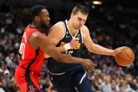 Denver Nuggets center Nikola Jokic, right, drives to the basket against Houston Rockets forward Bruno Fernando, left, during the third quarter of an NBA basketball game, Monday, Nov. 28, 2022, in Denver. (AP Photo/Jack Dempsey)