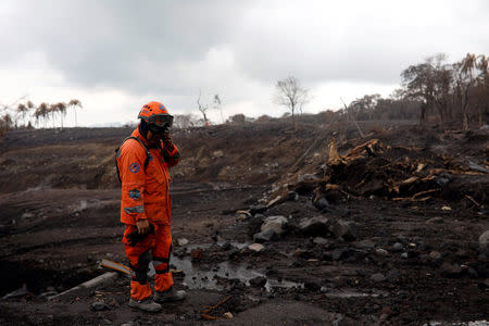 A member of the Guatemala's disaster management agency (CONRED) gestures while inspecting an area affected by a lahar from Fuego volcano at El Rodeo, Guatemala June 13, 2018. REUTERS/Jose Cabezas