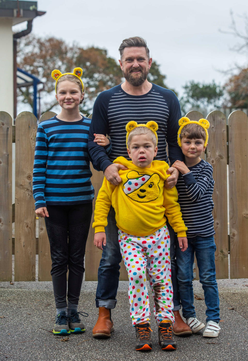 Stanley Barnes, 8, whose Mum is Mari, with his father Ross and sisters Willow aged 11, and Orson aged 6,  at the Mawnan Smith Primary School in Cornwall. See SWNS story SWPLalzheimers; A heartbroken mum says her son has stopped recognising her at the school gates after a rapid deterioration due to 'childhood Alzheimer's' - at the age of just EIGHT. Brave schoolboy Stanley Barnes was diagnosed with Sanfillipo, a condition likened to Alzheimer's, that means he can now no longer communicate with his parents or remember everyday words like 'apple'. And although he remains active, mum Mari Barnes, 40, says her son now doesn't even recognise her when she goes to pick him up from school. Stanley was first diagnosed with the condition aged just 16 months but has started to deteriorate and Mari says she feels like she is 