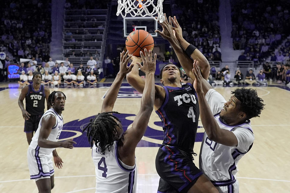 TCU guard Jameer Nelson Jr., center, gets between Kansas State guard Dai Dai Ames, left, and Kansas State forward Jerrell Colbert, right, to put up a shot during the first half of an NCAA college basketball game Saturday, Feb. 17, 2024, in Manhattan, Kan. (AP Photo/Charlie Riedel)