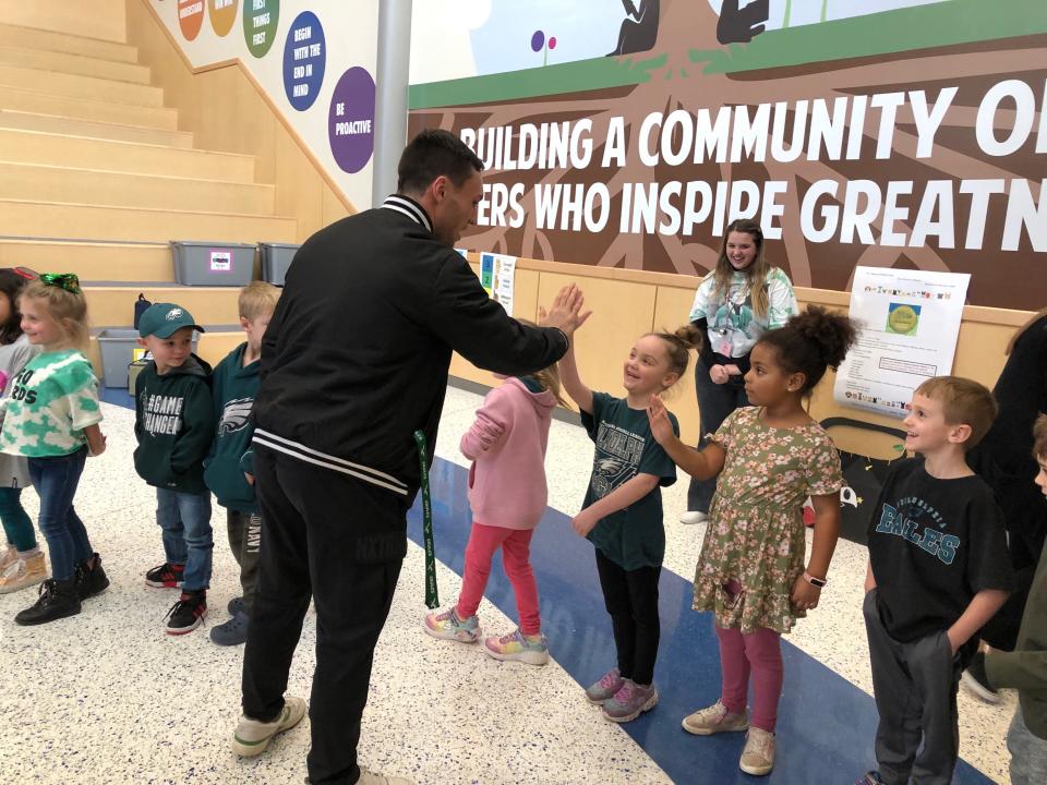 Eagles wide receiver Britain Covey gives a Neidig Elementary School student a high five during his visit to the school Wednesday.