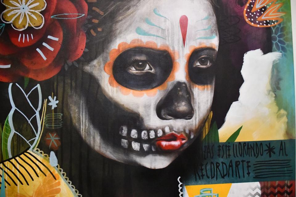 A close-up shows detail of a painting by Armando Silva, depicting face-painting to mark the Day of the Dead. The painting is part of an exhibit of Chicano art at El Pueblo History Museum in Pueblo, Colo., which runs until the end of 2022.