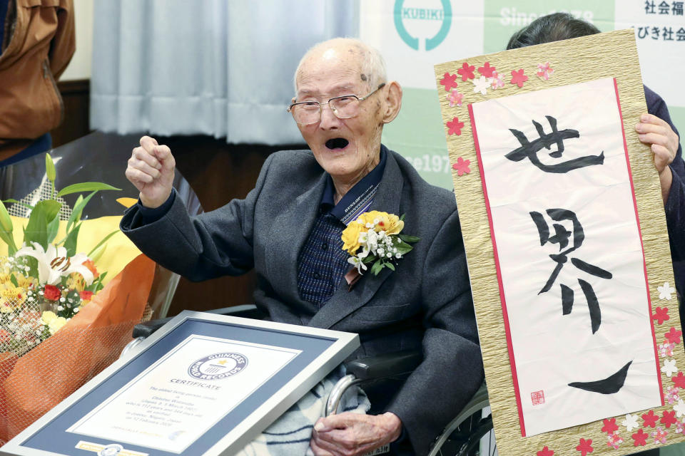 Chitetsu Watanabe, 112, poses next to the calligraphy he wrote after being awarded as the world's oldest living male by Guinness World Records, in Joetsu, Niigata prefecture, northern Japan Wednesday, Feb. 12, 2020. (Kyodo News via AP)