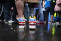 The shoes of 2013 Boston Marathon bombing survivor J.P. Norden read "Boston Strong" as he stands at the finish line on the one-year anniversary of the bombings in Boston, Massachusetts April 15, 2014. J.P. and his brother Paul, also a bombing survivor, took part in the final portion of the "Legs for Life Relay", joining family members and friends who walked the entire Marathon route to raise money for children needing prosthetic limbs. U.S. Vice President Joe Biden, other leaders and survivors of the Boston Marathon bombing shared messages of thanks and defiance on Tuesday at a tribute to the three people killed and 264 wounded in the attack exactly one year ago. REUTERS/Brian Snyder (UNITED STATES - Tags: SPORT ATHLETICS DISASTER CRIME LAW ANNIVERSARY TPX IMAGES OF THE DAY)